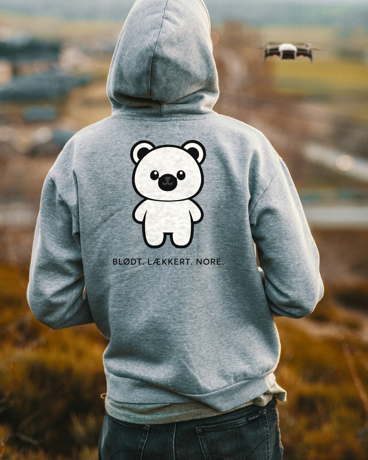 Grå hoodie med Bamse og sloganet Blødt. Lækkert. NORE. på ryggen